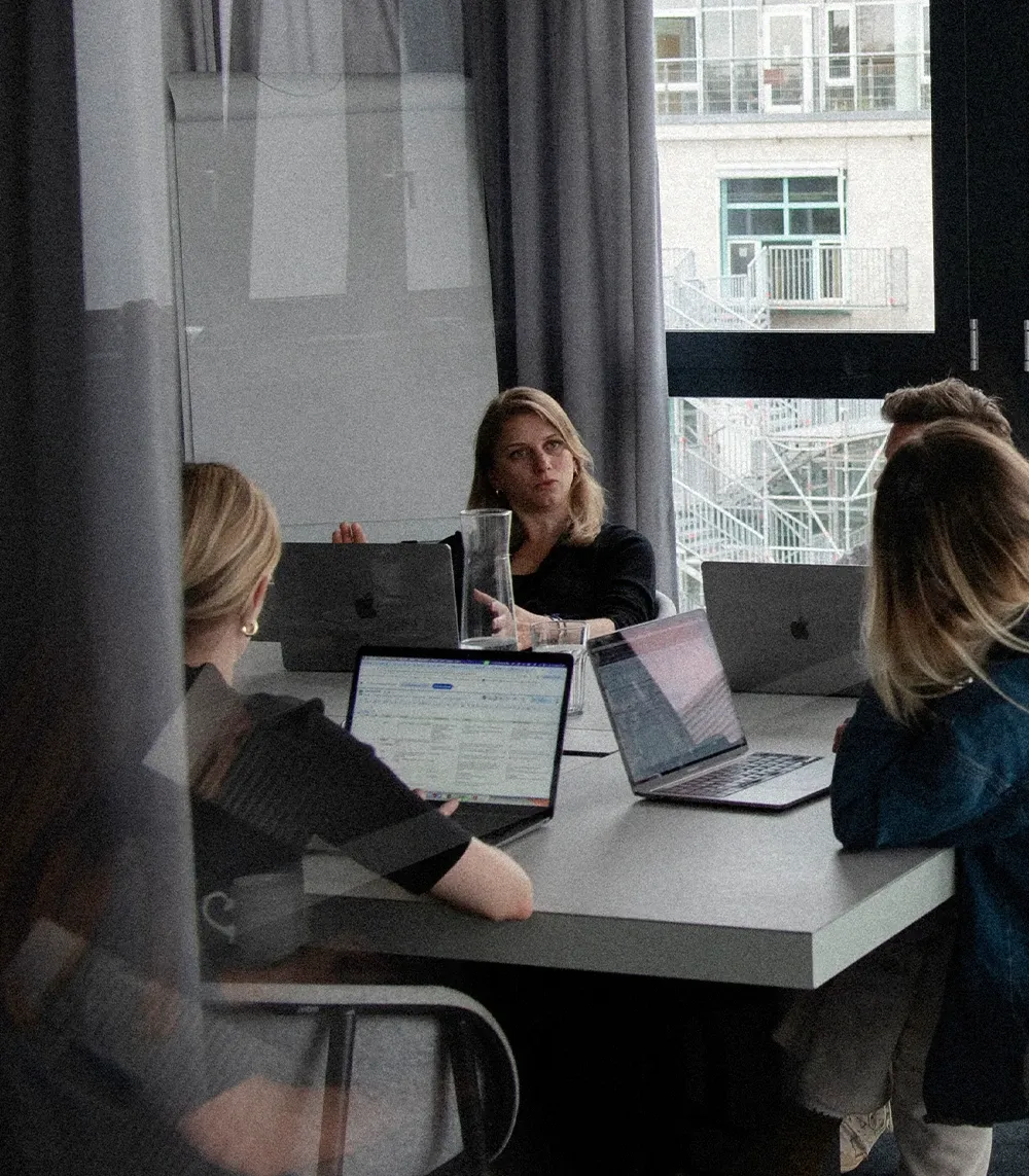Strategiebesprechung in einem Konferenzraum, Personengruppe an Laptops sitzend