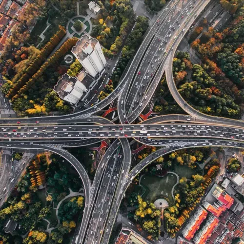 Luftaufnahme eines verzweigten Autobahnkreuzes in einer Großstadt - Digitale Ökosysteme Titel